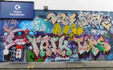 a colourful graffiti mural on the wall of the Vision Foundation Portobello Road shop
