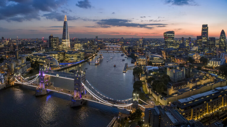 The London skyline at sunrise, showing key London landmarks such as the Shard, Tower Bridge, Tower of London.