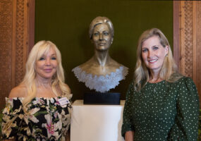 HRH The Countess of Wessex and sculptor, Frances Segelman stood either side of the newly unveiled bronze bust sculpture of HRH. The sculpture is bronze in colour, showing HRH with a tidy up-do and a relaxed face. There are hints of colour in her eyes and lips and a baby blue lace sculpted around her neckline.