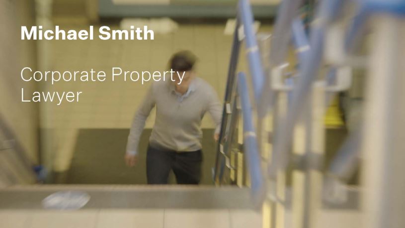 A still of Michael Smith and text displaying his name and job title: Corporate Property Lawyer