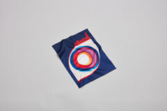 The latest Cubitts lens cloth. A dark blue cloth with a colourful graphic of an eye.