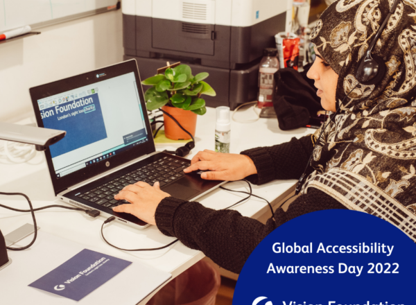 Khafsa sat at desk using access technology. Text: Global Accessibility Awareness Day 2022