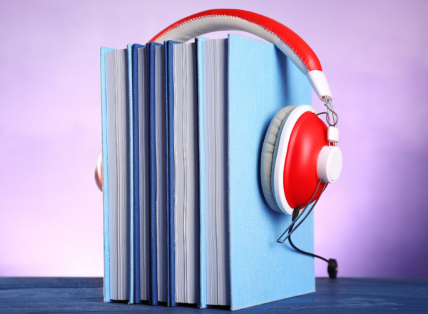 Stack of books with headphones put on top of them.