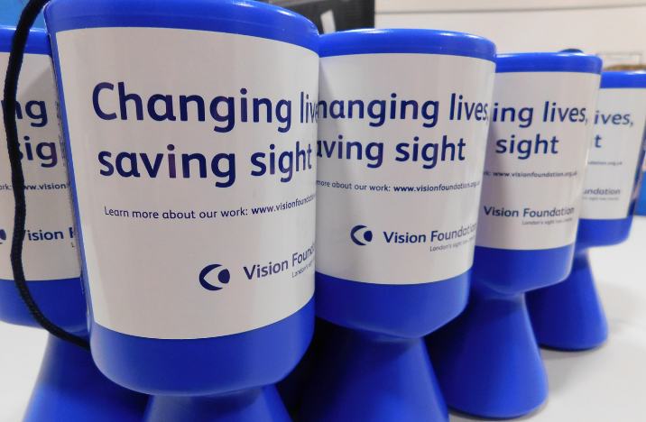 Vision Foundation collection tins. Blue with a white sticker that says Changing lives and saving sight