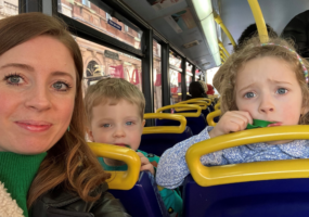 Fran with her children, Maisie and Reuben on a bus. They are all in a selfie.