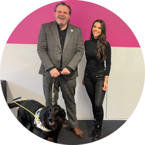 Gemma and Keith posing together for a photo with his guide dog, Dottie