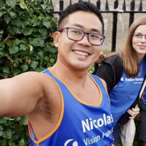 Nicolas posing for a selfie outside the Tower of London in a Vision Foundation running vest