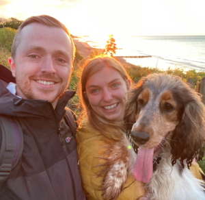 Hannah, her fiance, and her dog cuddled together for a sunset selfie.